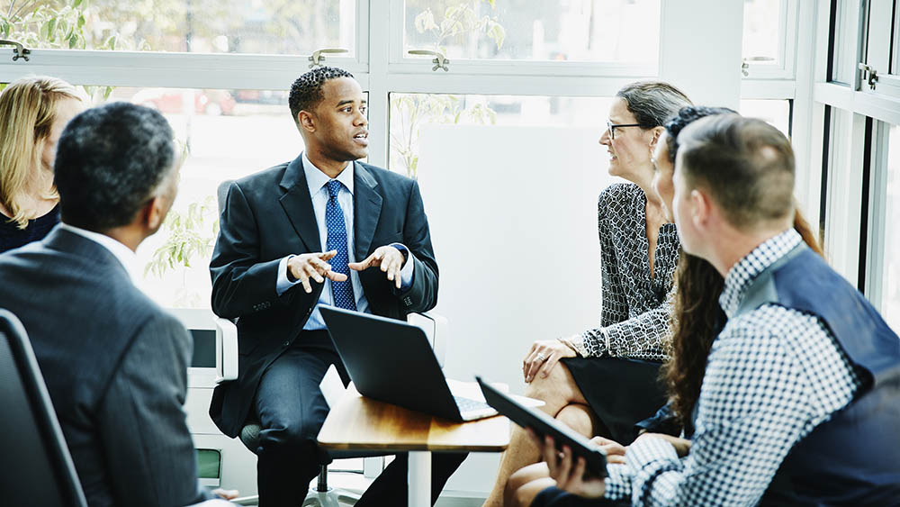 Businessman leading team meeting in office conference room